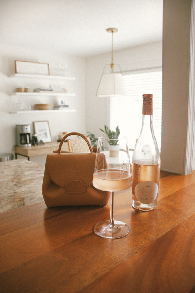 Polène Paris Numero Un Nano - Tan Textured Leather Crossbody Handbag next to Oree des Roses Rosé in Kitchen